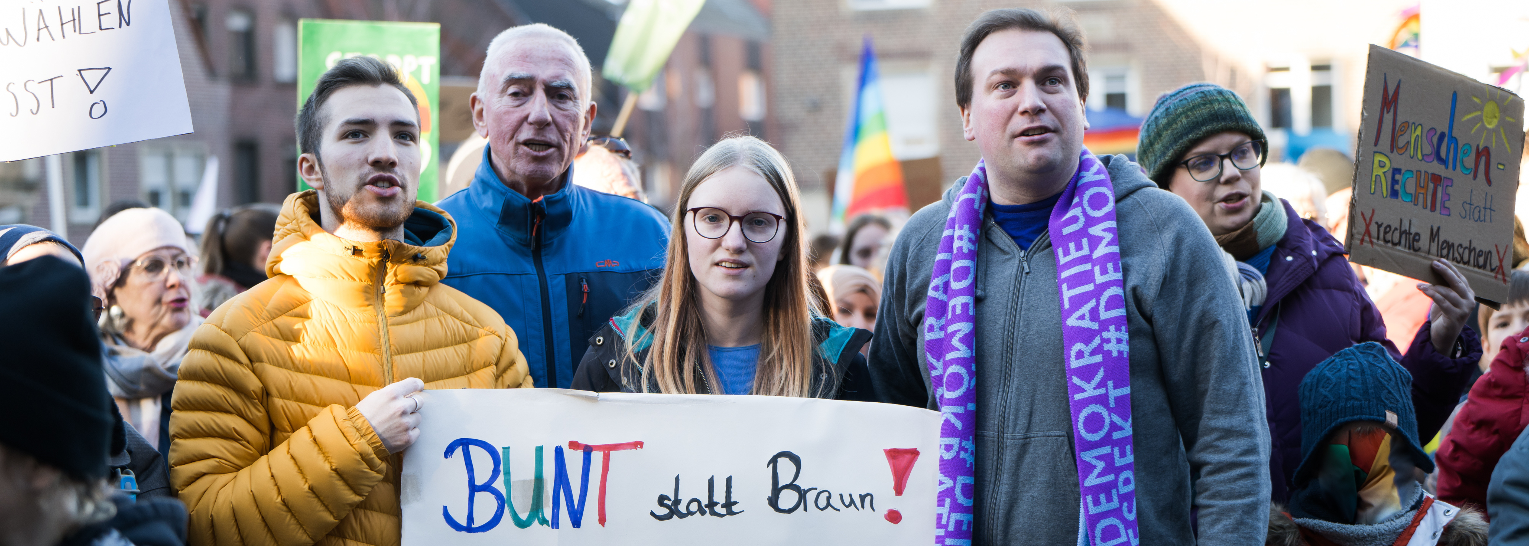 Vier Personen halten ein Schild: "Bunt statt Braun. Sport gegen Rechts."